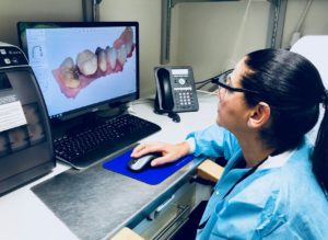 Dentist looking at a dental restoration on a computer screen